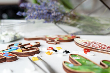 Multi-colored glass and wooden molds in the form of cactus, fish for mosaic, handicrafts