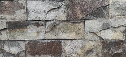 Brick background and the color is grey.