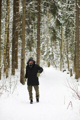 Fototapeta na wymiar Bearded man in the winter woods. Attractive happy young man with beard walk in the park.