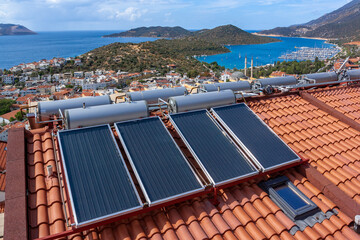 Solar water heater installed on tile roof of house for economical heating of water. A lot of large...
