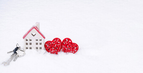 A bunch of keys of house and two hearts in snow - Valentine's Day, love in home. Couple housing, real estate, rent, mortgage, relocation. Comfort and warmth in love nest. 