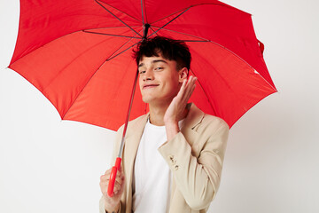 Man holding an umbrella in the hands of posing fashion light background unaltered