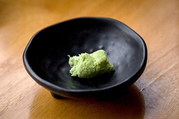 small heap of fresh ground wasabi on wooden table, Spicy dipping sauce is often eaten with sushi, Japanese food.