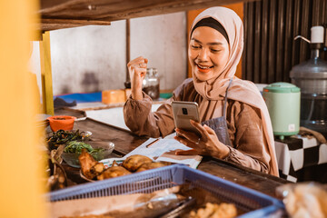 beautiful muslim seller taking order from customer