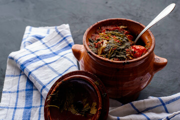 a pot of chanakhi and a towel on a dark background
