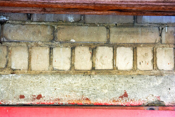 Brick wall with some bricks pristine and others marred, smudged, or chipped