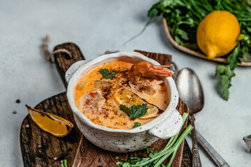 Shrimp soup with herbs, lemon and spices on wooden board, comfort food concept, healthy eating