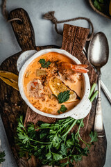 Shrimp soup with herbs, lemon and spices on wooden board, comfort food concept, healthy eating