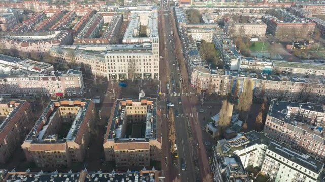 Aerial hyperlapse of the Javaplein square in Amsterdam East, busy urban city life at an intersection with trams pedestrians cars and cyclists.