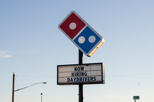 Seaside, OR, USA - Jan 22, 2022: Domino's sign with hiring ads is seen outside one of its locations in Seaside on the Oregon Coast amid the Omicron surge.