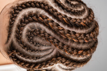 Close-up of braids on the head of a caucasian woman. - obrazy, fototapety, plakaty