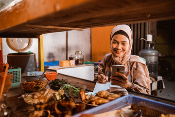 young female muslim working as a traditional food seller