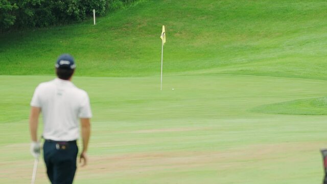 Golfer Watching Their Approach Shot Land Right Next to the Pin on a Golf Course