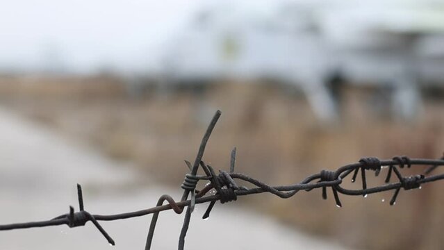 Footage of a closed area behind the barbed wire of a military airfield with old decommissioned Su-24 fighters. Autumn, cloudy.