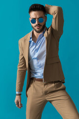 confident businessman in suit holding hand behind head