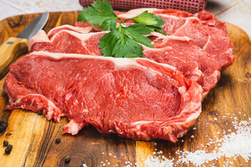  raw beef meat with spices and herbs on wooden cutting board