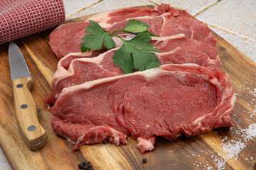 raw beef meat with spices and herbs on wooden cutting board