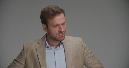 businessman slowly having a heart attack on gray background