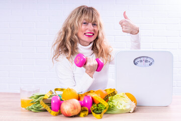 happy woman with dumbbells and healthy food making ok sign with her finger. healthy diet and sport concept