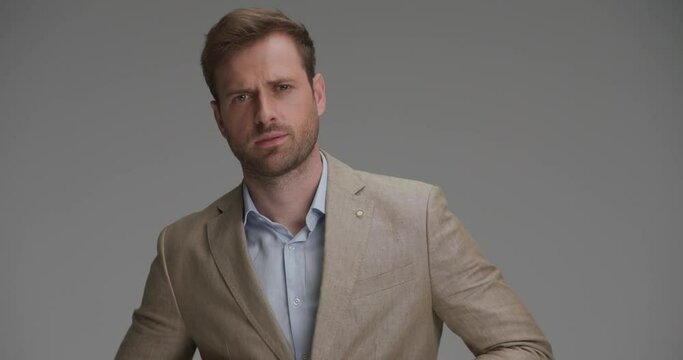 handsome businessman closing his suit, looking away and having a tough look