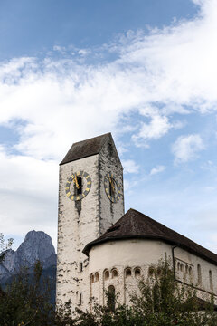 Alte Kirche unter blauem Himmel, bew&ouml;lkt, kirchenuhr, b&auml;ume, berge, wolken,