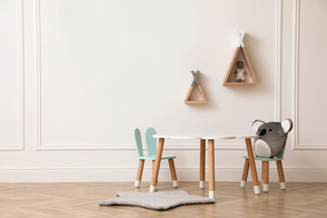 Cute child room interior with furniture, toys and wigwam shaped shelves on white wall. Space for...