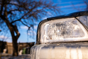 Fototapeta premium Shiny headlight on an old japanese 4 wd car on a bright sunny day, space for text.