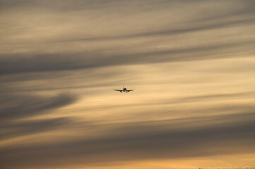 Plane in the evening sky in luminous horizon. It goes on vacation