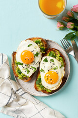 Healthy breakfast with eggs toast and orange juice on blue background