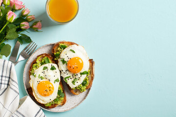 Healthy breakfast with eggs toast and orange juice on blue background