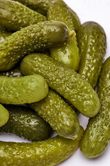 Pile of of Tasty canned Whole green cornichons isolated on a white background