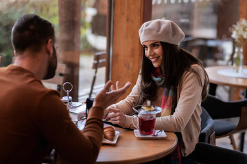 Happy couple sitting at the cafe and enjoying each other companion