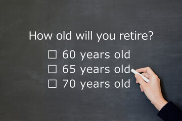 何歳に退職をするかの質問を黒板に描くビジネスマンの手元