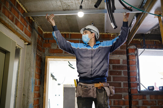 Worker measuring breadth with steel rod at construction site