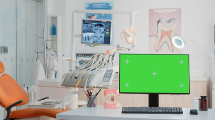 Empty dental cabinet with horizontal green screen on monitor. Nobody in dentist office for dentistry care with isolated background and mockup template on computer. Stomatological tools