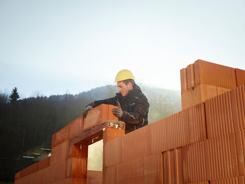 Construction worker fixing bricks at construction site