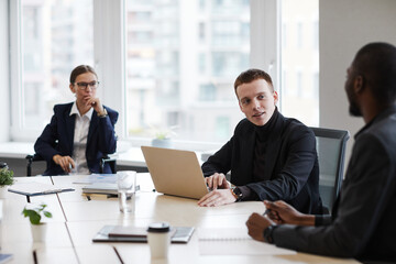 High angle portrait of successful businesswoman using wheelchair while leading business meeting in office with diverse group of people