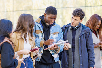 Multiracial friends discussing over book on campus