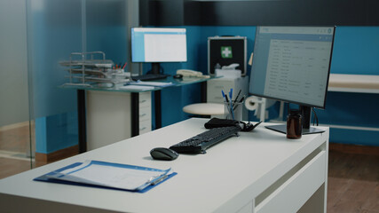 Nobody in cabinet with medical equipment for checkup visit and examination. Close up of desk with computer, documents and tools for consultation in empty doctors office at facility.