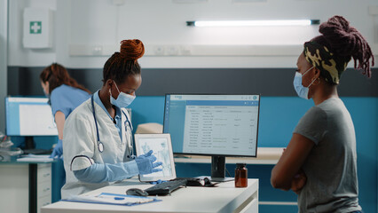 Specialist holding tablet with bones for orthopedic checkup visit, showing human skeleton anatomy...