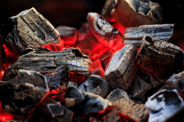 Hot white and black coals smolder in the grill