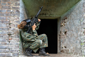 woman in uniform with a gun in military paintball training