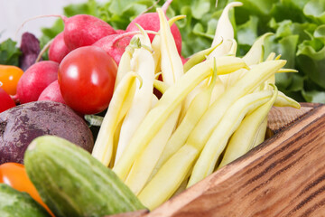 Fresh ripe vegetables in wooden box as healthy snack containing vitamins