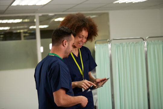 Medical colleagues discussing on tablet PC in medical room