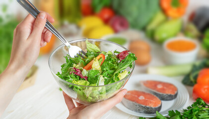 Hands holding green salad bowl. Health care and weight loss concept.