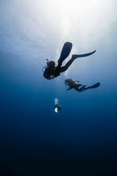 Friends with diving equipment in blue sea