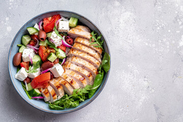 Grilled chicken breast. Fried chicken fillet and fresh vegetable salad with tomatoes, cucumber and feta cheese. Chicken meat with salad. Healthy food.