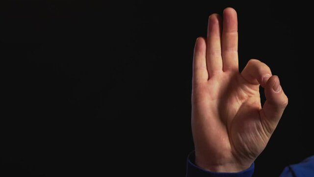 hand gestures on black background
male hand showing a gesture "everything is fine"