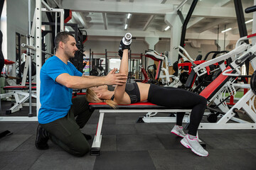 two young trainers a man and a woman train in the gym to maintain the health of their bodies.