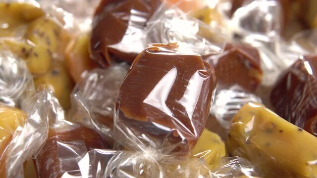 Different toffee candy close up. Wrapped taffy candies. Christmas treats. Taffy-toffy. Macro. Rotation